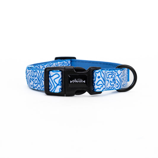 A blue dog collar with a swirly pattern and a black padded clasp.